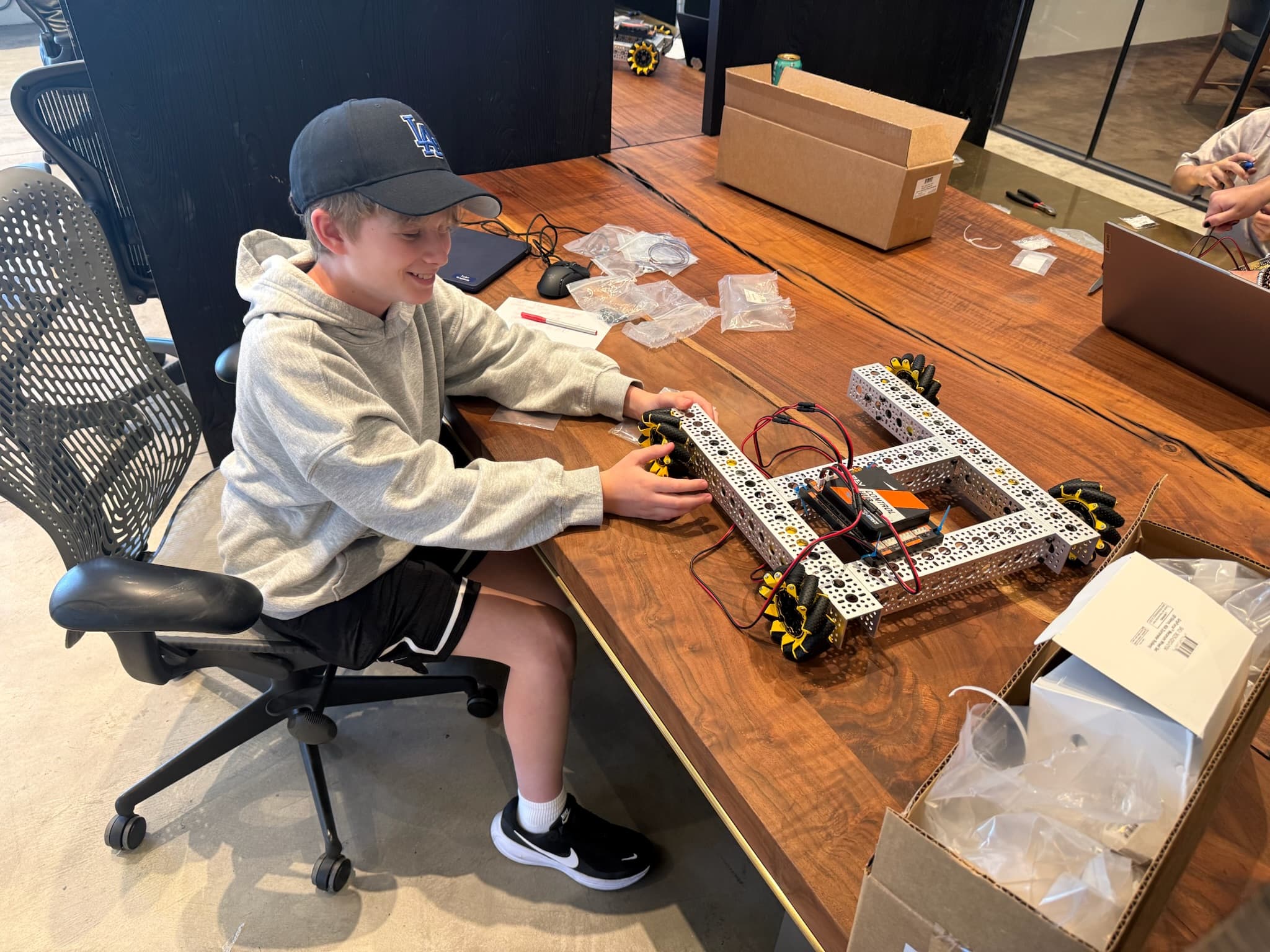 Student assembling a robotics drivetrain at Camp Asimov